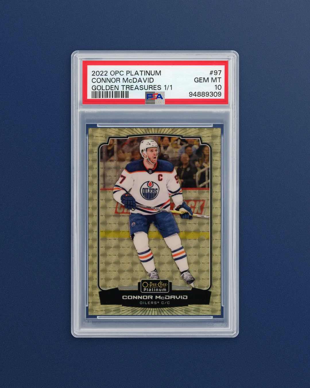 A Connor McDavid Golden Treasures 1/1 on a navy Texture background